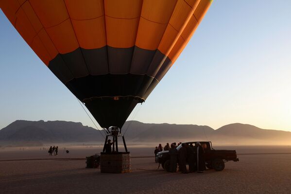 طاقم يقوم بإعداد المنطاد قبل الإقلاع خلال مهرجان منطاد الهواء الساخن في صحراء وادي رم، الأردن، 1 أكتوبر 2021. - سبوتنيك عربي