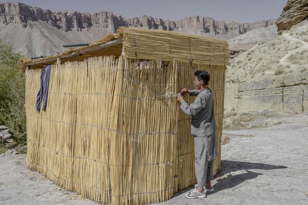 شاب يغلق كوخه بجوار بحيرة بان أمير في مقاطعة باميان في 4 أكتوبر 2021. - سبوتنيك عربي