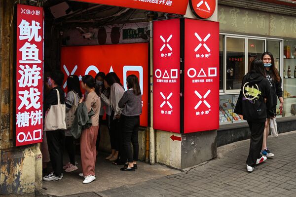 دمية بطول 3 أمتار من مسلسل لعبة الحبّار (Squid Game) المعروض على شبكة نتفليكس، خارج مركز تجاري يبيع حلوى البسكويت من طفولة الكوريين التي كانت ضمن المسلسل ( dalgonas /Honeycomb toffee) في كويزون سيتي، الفلبين، 30 سبتمبر 2021. - سبوتنيك عربي