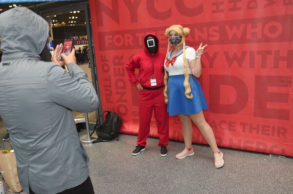 أشخاص يرتدون أزياء شخصيات من مسلسل لعبة الحبّار (Squid Game) المعروض على شبكة نتفليكس ومسلسل الكرتون سايلور مون، خلال مهرجان كوميك كون 2021 في نيويورك، الولايات المتحدة، 9 أكتوبر2021. - سبوتنيك عربي