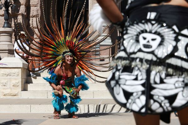 أعضاء من فرقة الرقص دانزا أزتيكا غوادالوبانا (Danza Azteca Guadalupana) يرقصون خلال الاحتفال بيوم الشعوب الأصلية في أراضي الكابيتول في أوستن، ولاية تكساس، الولايات المتحدة، 9 أكتوبر 2021. - سبوتنيك عربي