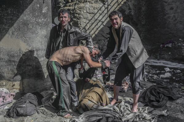 موظفو مستشفى ابن سينا الطبي للعلاج من تعاطي المخدرات في كابول يحاولون اقناع مدمنا للمجئ معهم، أفغانستان 16 أكتوبر 2021 - سبوتنيك عربي