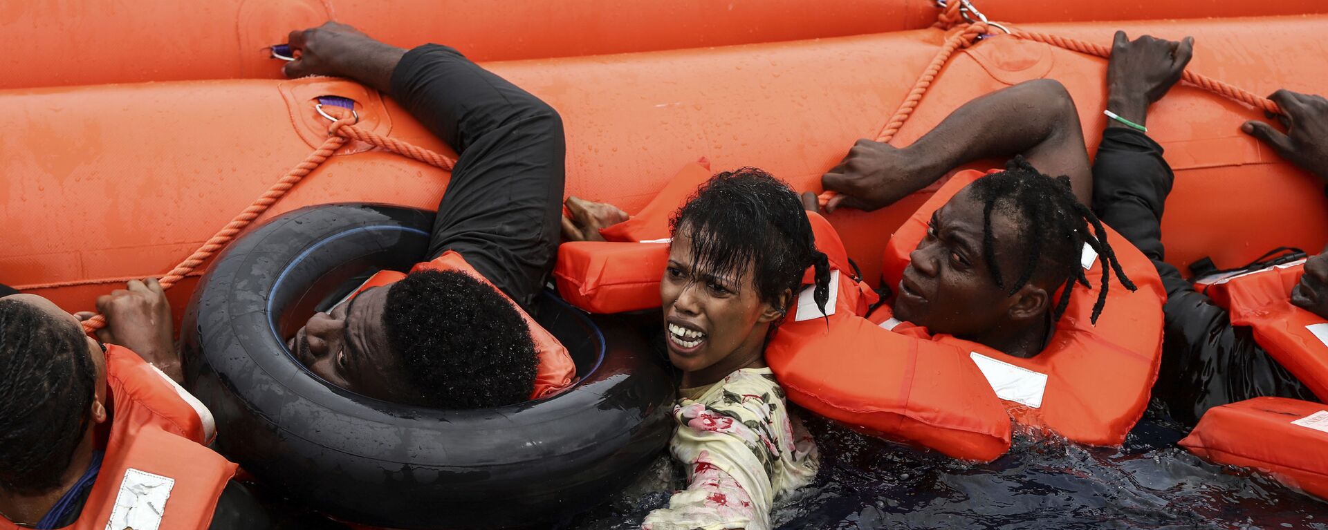 انقاذ مهاجرين من قبل فريق من حفر السواحل  سي ووتش-3 على بعد حوالي 35 ميلاً من ليبيا، في نطاق منطقة البحث والإنقاذ الليبية، 18 أكتوبر 2021. - سبوتنيك عربي, 1920, 14.04.2022