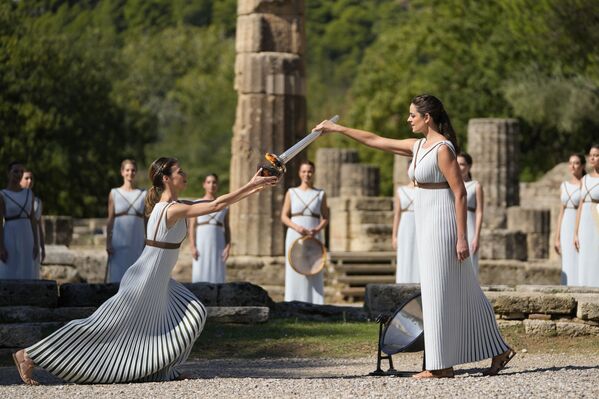 الممثلة اليونانية زانثي جورجيو، إلى اليمين، تلعب دور الكاهنة العليا، تحمل الشعلة أثناء إضاءة الشعلة الأولمبية في موقع أولمبيا الأثري، مسقط رأس الألعاب الأولمبية القديمة في جنوب غرب اليونان، 18 أكتوبر 2021. سيتم نقل الشعلة بواسطة تتابع الشعلة إلى بكين، الصين، التي ستستضيف دورة الألعاب الأولمبية الشتوية من 4 إلى 20 فبراير 2022.
 - سبوتنيك عربي