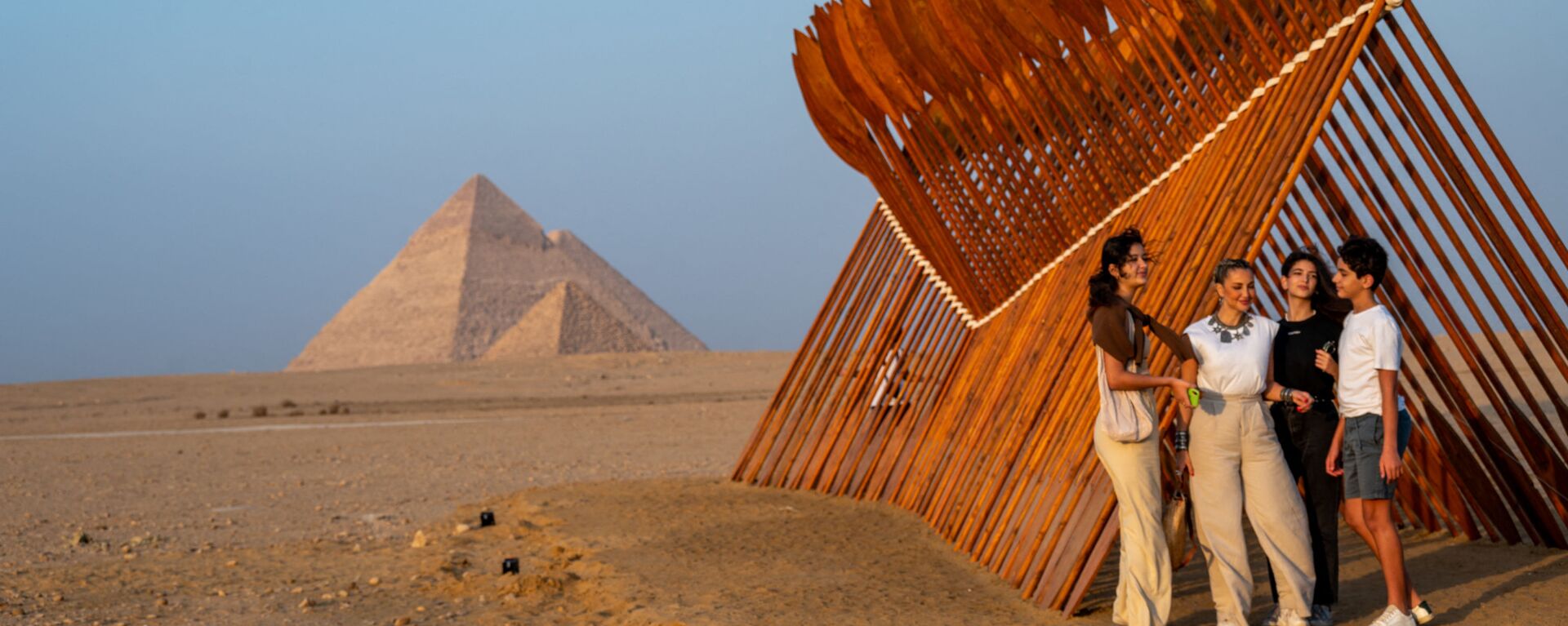 سياح يقفون بالقرب من تركيب فني بعنوان بطرخ للفنان المصري معتز نصر، في معرض الأبد هو الآن على خلفية الأهرامات في الجيزة، مصر 23 أكتوبر 2021. - سبوتنيك عربي, 1920, 08.05.2022