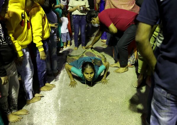 امرأة هندوسية ترقد على الطريق، احتراما، أثناء وصولها لعبادة إله الشمس خلال المهرجان الديني لـتشاهاث بوجا في كولكاتا، الهند، 11 نوفمبر 2021. - سبوتنيك عربي