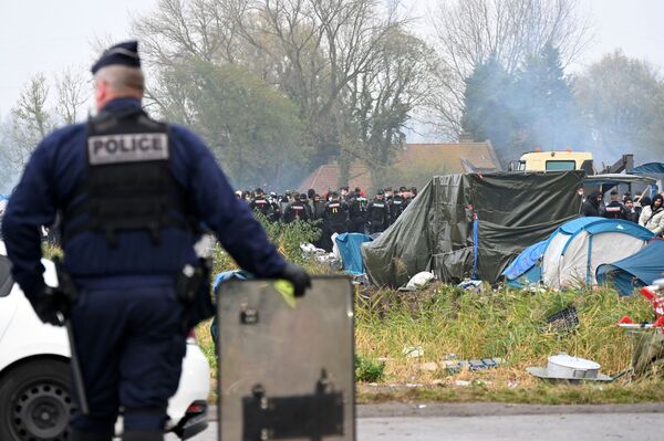 قوات الشرطة الفرنسية تراقب المخيم المؤقت للمهاجرين في غراند سينث، شمال فرنسا، 16 نوفمبر 2021 - سبوتنيك عربي