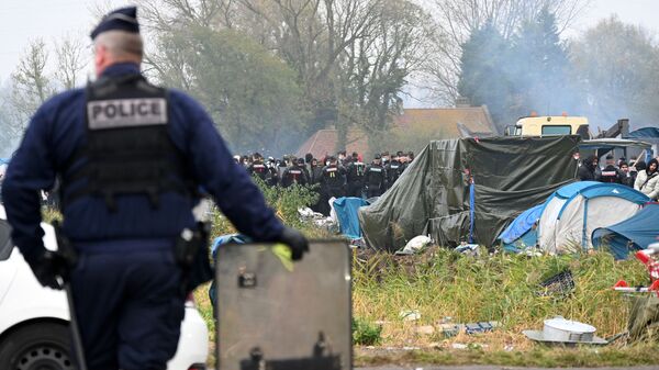 قوات الشرطة الفرنسية تراقب المخيم المؤقت للمهاجرين في غراند سينث، شمال فرنسا، 16 نوفمبر 2021 - سبوتنيك عربي