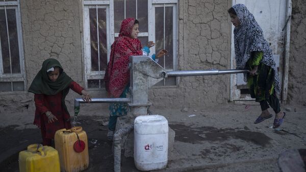 فتيات يملأن حاويات بالمياه باستخدام مضخة يدوية في مخيم للنازحين في كابول، أفغانستان، 15 نوفمبر 2021. - سبوتنيك عربي