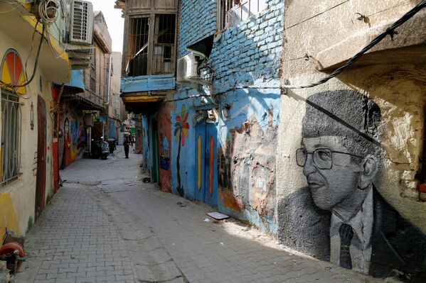 منظر لممر عليه لوحات جدارية رسمتها مجموعة من الرسامين العراقيين الذين تطوعوا لطلاء جدران منازل الأحياء القديمة لتزيين مدينتهم في حي الكاظمية في بغداد، العراق، 30  نوفمبر 2021 - سبوتنيك عربي