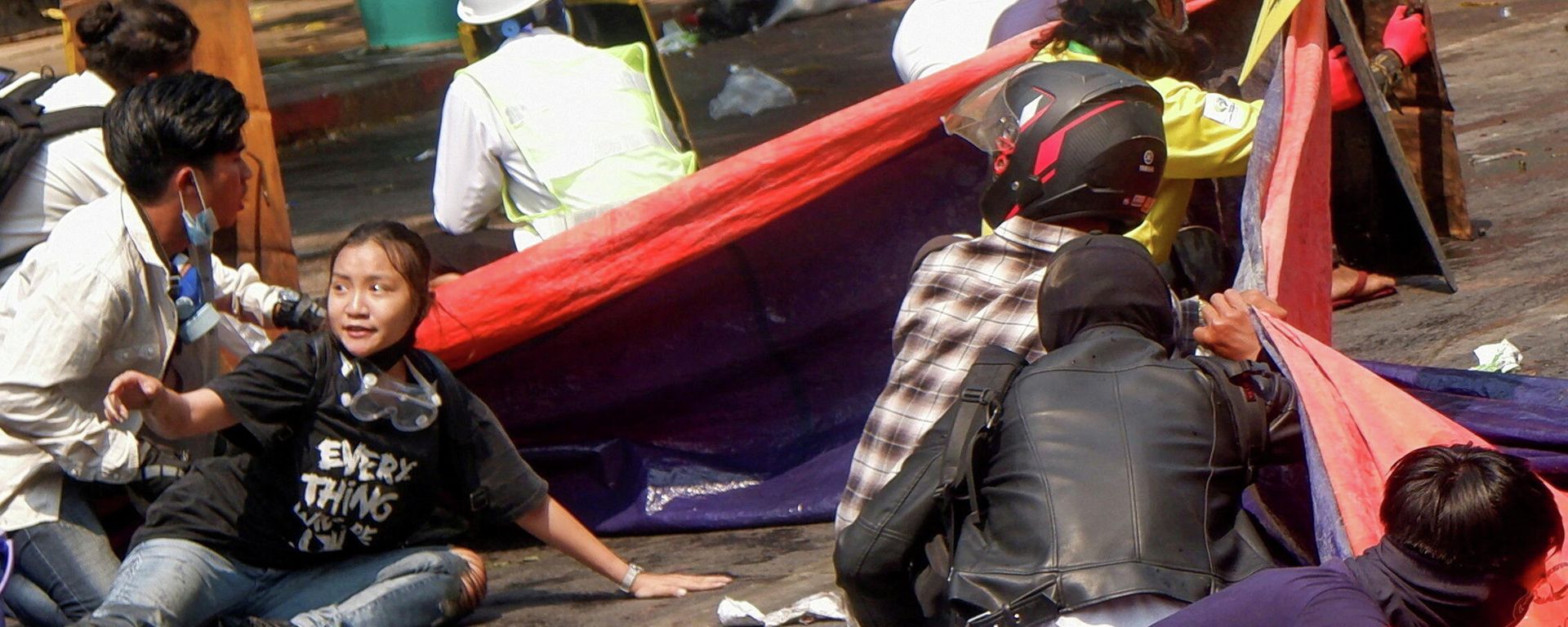 المتظاهرون يرقدون على الأرض بعد أن فتحت الشرطة النار لتفريق مظاهرة مناهضة للانقلاب في ماندالاي، ميانمار، 3 مارس/ آذار 2021 - سبوتنيك عربي, 1920, 05.12.2021