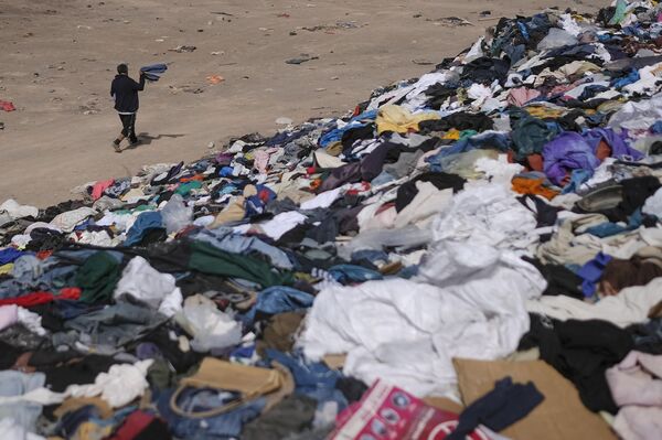 ألكسيس كارينو يسير بجوار كومة كبيرة من الملابس المستعملة بالقرب من حي لا مولا في ألتو هوسبيسيو، تشيلي، 13 ديسمبر 2021 - سبوتنيك عربي