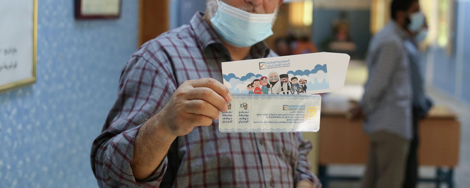 رجل يُظهر بطاقته الانتخابية داخل مركز اقتراع في طرابلس، ليبيا في 8 نوفمبر 2021 - سبوتنيك عربي, 1920, 23.12.2021