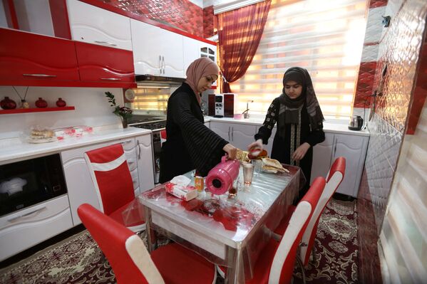 الملاكمة العراقية، بشرى عبد الزهرة، البالغة من العمر 36 عامًا، تحضر الطعام مع انبتها بمنزلها في النجف، العراق ، 24 ديسمبر 2021 - سبوتنيك عربي