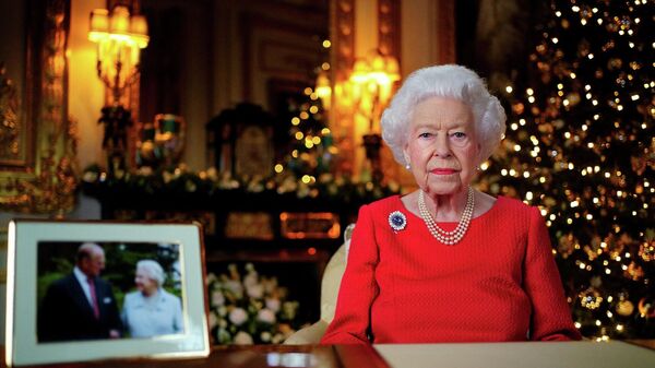 ملكة بريطانيا، إليزابيث الثانية، أثناء تسجيل بثها السنوي لعيد الميلاد في غرفة الرسم البيضاء في قلعة وندسور، 23 ديسمبر/ كانون الأول 2021 - سبوتنيك عربي