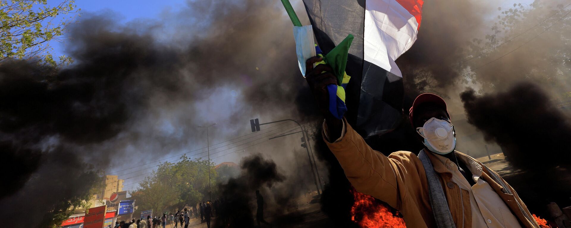 متظاهر في السودان يرفع علم بلاده أثناء احتجاجات الجمعة 31 ديسمبر  - سبوتنيك عربي, 1920, 29.01.2022