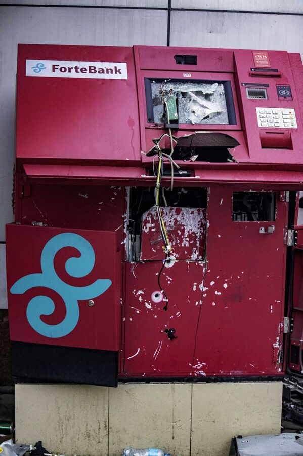 آلة صراف آلي نهبها لصوص خلال أعمال شغب في أحد شوارع مدينة ألماتي، كازاخستان 9 يناير 2021 - سبوتنيك عربي