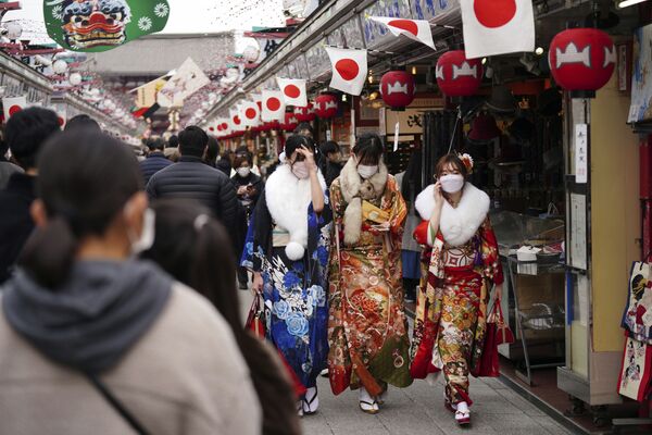نساء يرتدين كيمونو يحتفلن ببلوغ سن العشرين، يمشون معًا بعد احتفال لتكريم البالغين سن الرشد بالقرب من معبد سينسوجي في منطقة أساكوسا،  في طوكيو، اليابان 10 يناير  2022.  - سبوتنيك عربي