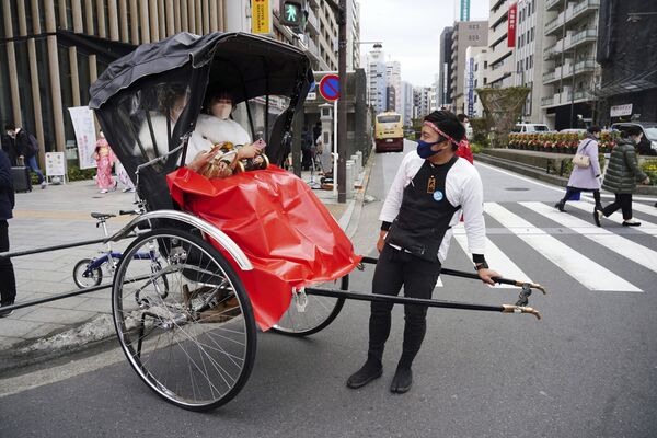 نساء يرتدين كيمونو يحتفلن ببلوغ سن العشرين، يركبن عربة ريكاشة بعد حفل بلوغ سن الرشد في طوكيو، اليابان، 10 يناير  2022 . - سبوتنيك عربي