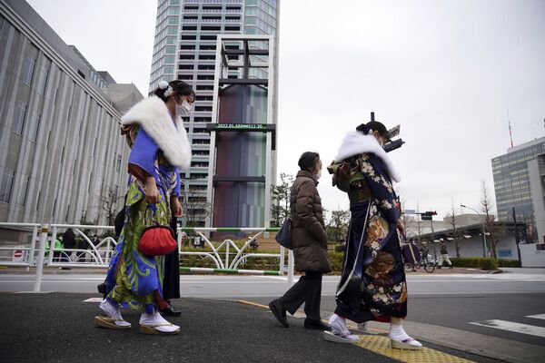 نساء يرتدين كيمونو يحتفلن ببلوغ سن العشرين، يشاركن في احتفال بلوغ سن الرشد في منطقة شيبويا بطوكيو، اليابان 10 يمناير 2021 - سبوتنيك عربي