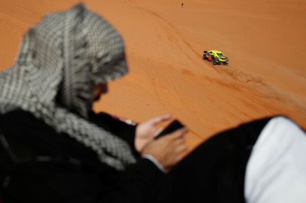  منظر عام خلال المرحلة 7 من رالي داكار 2022 مع متفرج يستخدم هاتف محمول، الرياض إلى الدوادمي، المملكة العربية السعودية، 9 يناير 2022 - سبوتنيك عربي