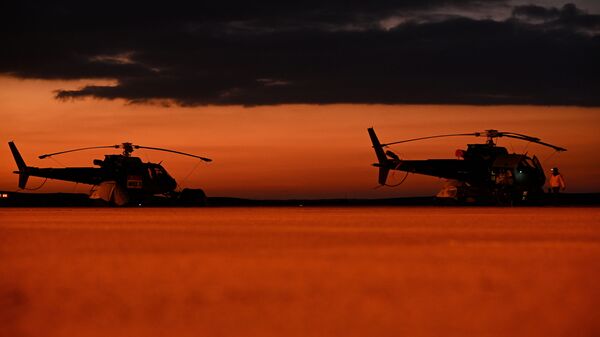 تنتشر طائرات هليكوبتر قبل المرحلة الثالثة من رالي داكار 2022 بين منطقتي الأرطاوية والقيصومة، 4 يناير 2022. - سبوتنيك عربي