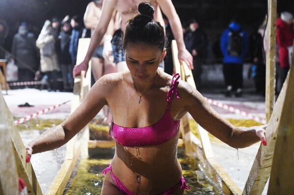 فتاة تخرج من بركة مياه جليدية على نهر أوب في نوفوسيبيرسك خلال الاحتفال بعيد الغطاس، 18 يناير 2022 - سبوتنيك عربي