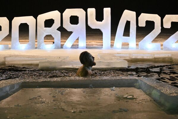 رجل يغطس في بركة مياه جليدية خلال الاحتفال بعيد الغطاس على بحيرة فياتشا في بيلاروسيا، 18 يناير 2022 - سبوتنيك عربي