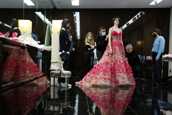 المصمم اللبناني إيلي صعب ومساعديه خلال قبل عرض أزياء مجموعة "هوت كوتور لربيع/ صيف 2022" في باريس، فرنسا 26 يناير 2022. - سبوتنيك عربي