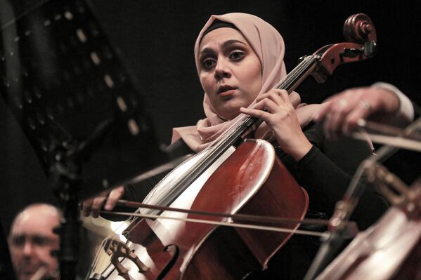عازفة التشيلو من الأوركسترا السيمفونية العراقية تؤدي مع عازفين آخرين في حفل موسيقي خلال ليالي بغداد الثقافية، على المسرح الوطني العراقي في بغداد، العراق 29 يناير 2022. - سبوتنيك عربي
