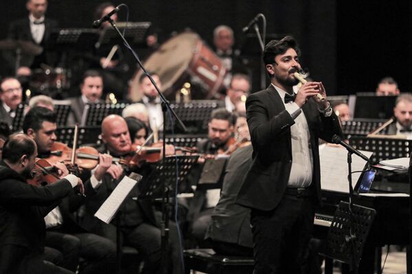 فرقة الأوركسترا السيمفونية الوطنية العراقية  تؤدي مقطوعات موسيقية في حفل موسيقي خلال ليالي بغداد الثقافية، على المسرح الوطني العراقي في بغداد، العراق 29 يناير 2022. - سبوتنيك عربي