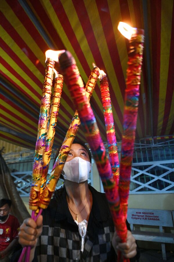 أحد المتعبدين يشعل البخور في أحد المعابد بمناسبة بداية السنة القمرية الجديدة في تا خماو، مقاطعة كاندال، إيذانًا بعام النمر، كمبوديا 1 فبراير 2022. - سبوتنيك عربي