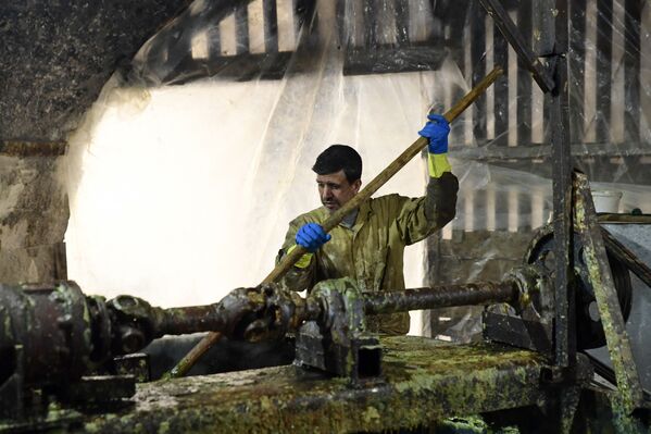 عامل سوري يشرف على صناعة صابون الغار في مصنع الجبيلي للصابون، الواقع في مدينة حلب القديمة شمال سوريا، 24 يناير 2022. - سبوتنيك عربي