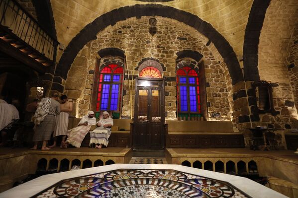 أحد موظفي الحمام يضع منشفة على زبون في حمام عام في دمشق، سوريا 22 يناير 2022. - سبوتنيك عربي