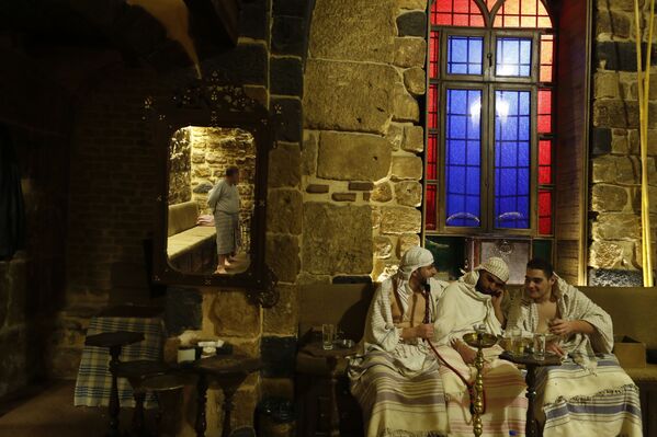 أحد موظفي الحمام يضع منشفة على زبون في حمام عام في دمشق، سوريا 22 يناير 2022. - سبوتنيك عربي