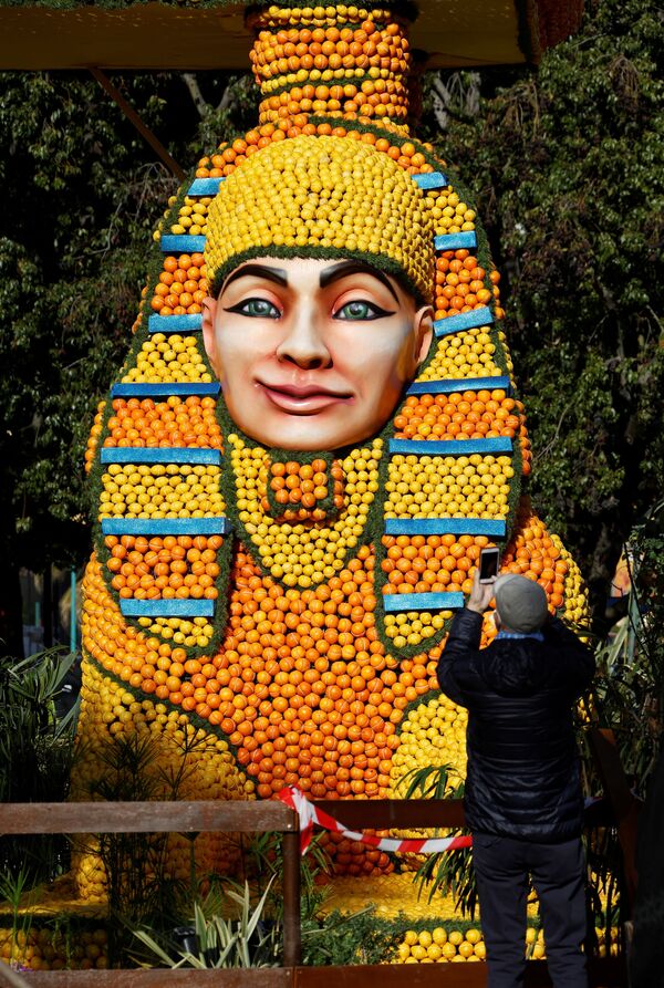 رجل يلتقط صورة لتمثال مصنوع من الليمون والبرتقال يُدعى "أيدا"، خلال مهرجان الليمون الـ 88 بعنوان "الأوبرا والرقص" في مينتون، فرنسا، 10 فبراير 2022. - سبوتنيك عربي