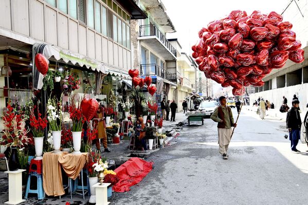 بائع متجول يحمل بالونات على شكل قلب بينما ينتظر العملاء في عيد الحب في كابول، أفغانستان 14 فبراير 2022. - سبوتنيك عربي