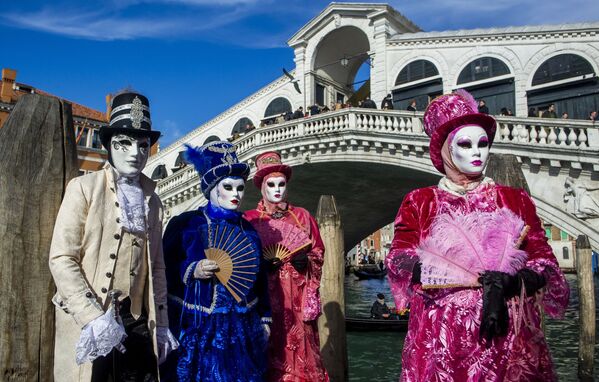 المحتفلون يرتدون أقنعة وأزياء كرنفال للاحتفال بكرنفال البندقية، في قناة البندقية، إيطاليا، 12 فبراير 2022 - سبوتنيك عربي