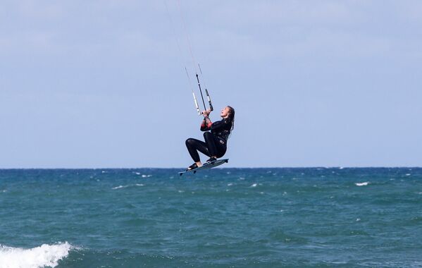 طالبة في كلية علوم الأحياء البحرية لينا آيت علي سليمان، تمارس ركوب الأمواج الشراعي في البحر الأبيض المتوسط ​​في مجمع "لو غراند بلو" (Le Grand Bleu) السياحي في بومرداس، الجزائر، 25 فبراير 2022. - سبوتنيك عربي