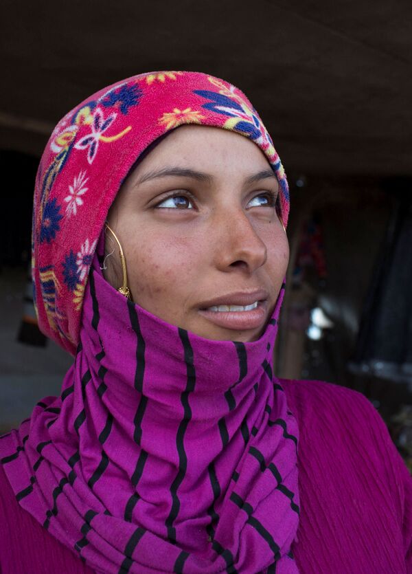 ليلى، تنظر خارج خيمتها أثناء إقامتها على الطريق السريع المؤدي إلى العاصمة القاهرة، في محافظة كفر الشيخ بدلتا النيل في مصر، 19 فبراير/شباط 2022.  - سبوتنيك عربي