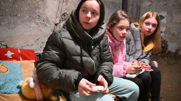 أطفال يغادرون الملجأ بعد إلغاء الإنذار بقصف القوات المسلحة الأوكرانية في قرية منجم غاغارين في غورلوفكا، منطقة دونيتسك، أوكرانيا 8 مارس 2022 - سبوتنيك عربي