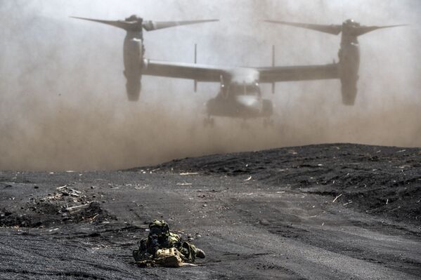 عضو في لواء الانتشار السريع البرمائي التابع لقوات الدفاع الذاتي اليابانية على خلفية إقلاع طائرة مشاة البحرية الأمريكية MV-22 Osprey أثناء تدريب مشترك مع أفراد من مشاة البحرية الأمريكية في منطقة تدريب هيغاشيفوجي في غوتيمبا، محافظة شيزوكا، اليابان 15 مارس 2022. - سبوتنيك عربي