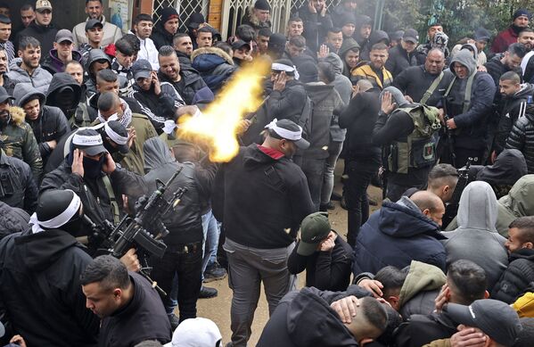 مسلح يطلق النار في الهواء خلال تشييع جنازة الفلسطيني نادر ريان البالغ من العمر 16 عاما، الذي استشهد برصاص القوات الإسرائيلية، في مخيم بلاطة بالقرب من مدينة نابلس شمال نابلس، 15 مارس 2022 - سبوتنيك عربي