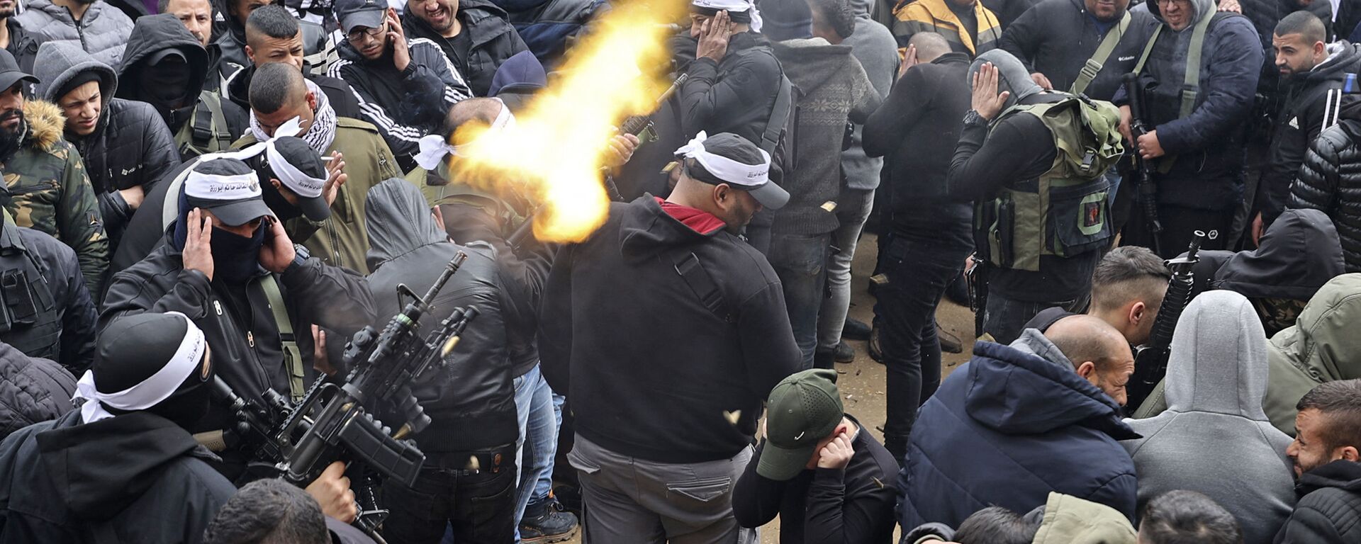 مسلح يطلق النار في الهواء خلال تشييع جنازة الفلسطيني نادر ريان البالغ من العمر 16 عاما، الذي استشهد برصاص القوات الإسرائيلية، في مخيم بلاطة بالقرب من مدينة نابلس شمال نابلس، 15 مارس 2022 - سبوتنيك عربي, 1920, 20.09.2022