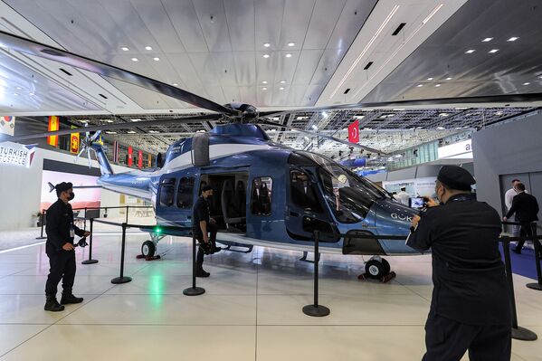 الحاضرون يقفون لالتقاط صورة لطائرة هليكوبتر تركية للنقل الخفيفTAI T625 Gökbey في معرض الدوحة الدولي للدفاع البحري (DIMDEX)، في الدوحة، قطر 21 مارس 2022. - سبوتنيك عربي