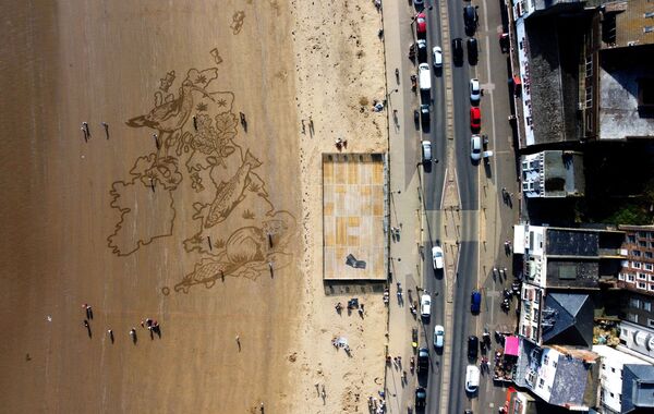 منظر جوي لرسم رملي ضخم على شاطئ ساوث باي، أنشأه فريق ساند إن يور آيز (Sand in Your Eyes) لتسليط الضوء على قلق الشباب من فقدان الحياة البرية، في سكاربورو، بريطانيا، 23 مارس 2022. - سبوتنيك عربي