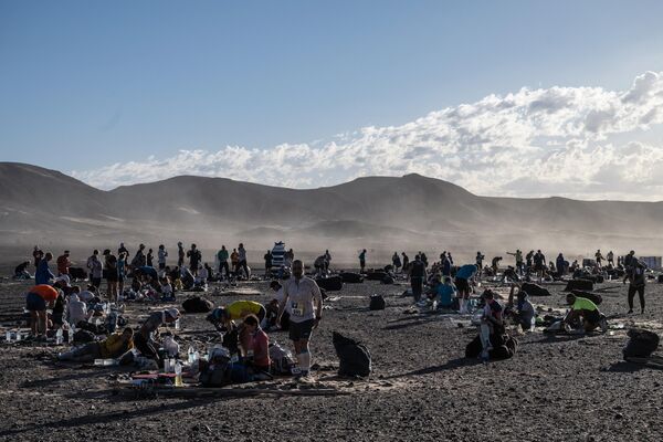 المتسابقون يأخذون استراحة في المرحلة 3 من النسخة الـ36 من ماراثون الرمال بين ريتش مبيريكا ونورد المحارش في الصحراء المغربية، وسط المغرب، 29 مارس 2022. - سبوتنيك عربي