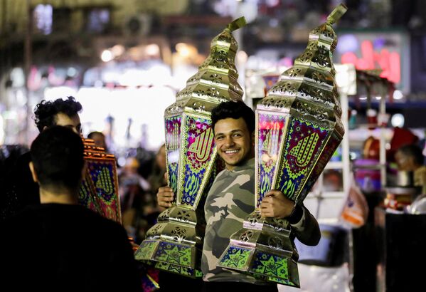 رجل يحمل فوانيس رمضانية تقليدية تسمى فانوس في كشك قبل شهر رمضان المبارك، في القاهرة، مصر، 31 مارس 2022. - سبوتنيك عربي
