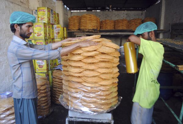 باكستانيون يصنعون الحلويات التقليدية في سوق لعرضها للبيع قبل شهر صيام رمضان القادم في حيدر أباد، باكستان، 2 أبريل 2022. - سبوتنيك عربي