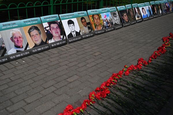 زهور وصور لمن قتلوا في مبنى نقابات عمال أوديسا في فعالية حداد بعنوان  نتذكر بالقرب من السفارة الأوكرانية في موسكو، 2 مايو 2018 - سبوتنيك عربي
